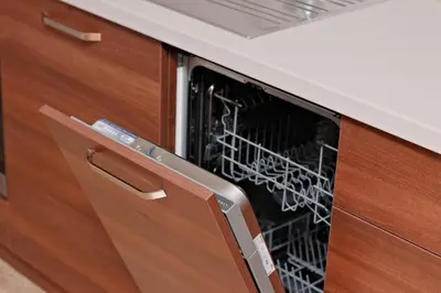 a dishwasher in a kitchen with wooden cabinets at Апартамент за гости Дарива in Smolyan