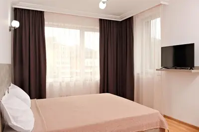 a hotel room with a bed and a window at Апартамент за гости Дарива in Smolyan