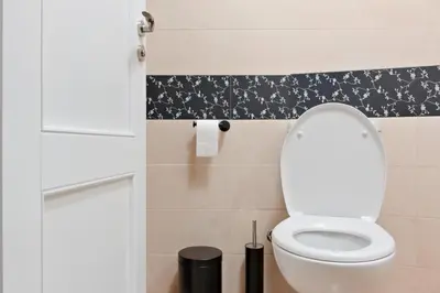 a bathroom with a toilet with a black and white pattern at Апартамент за гости Дарива in Smolyan