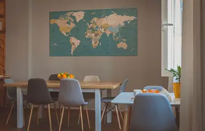 a dining room with a table with chairs and a map on the wall at Temple House in Plovdiv