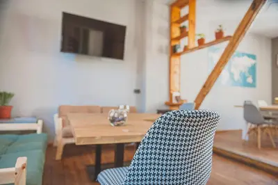 a living room with a wooden table and a blue chair at Temple House in Plovdiv