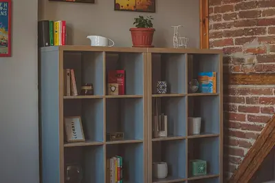 a wooden book shelf with many books on it at Temple House in Plovdiv