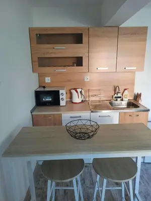 a kitchen with a table and two stools at Апартаменти за гости ,,Тракия'' in Hisarya
