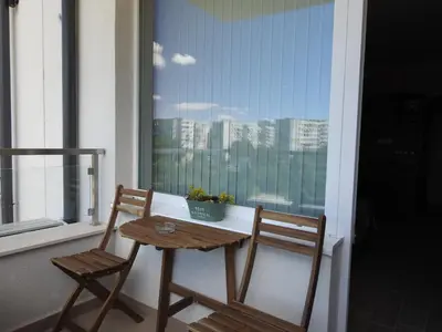 two chairs and a table on a balcony with a window at Vintage Studio Mladost in Sofia