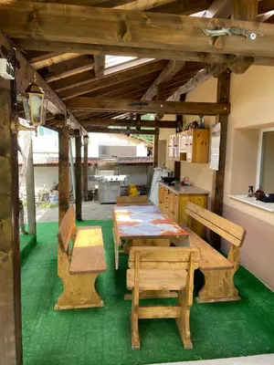 a kitchen with wooden tables and benches in a room at Св.Георги in Sapareva Banya