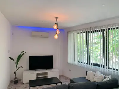 a living room with a couch and a flat screen tv at Nordic Style Apartment with Parking place in Sofia