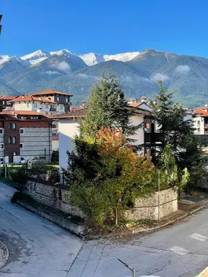 a city street with buildings and trees and mountains at Private Apartments next to Bellevue Residence in Bansko