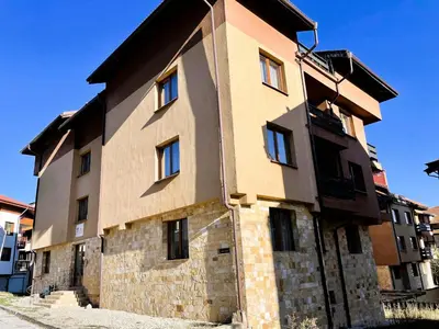 a large brick building with windows on the side of it at Private Apartments next to Bellevue Residence in Bansko