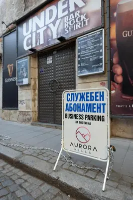 a sign sitting on the sidewalk in front of a store at Aurora Hills Hotel in Plovdiv
