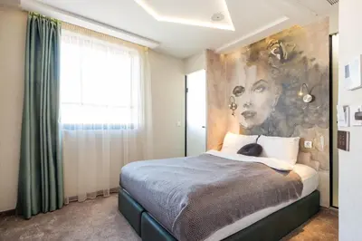 a bedroom with a bed with a painting on the wall at Aurora Hills Hotel in Plovdiv