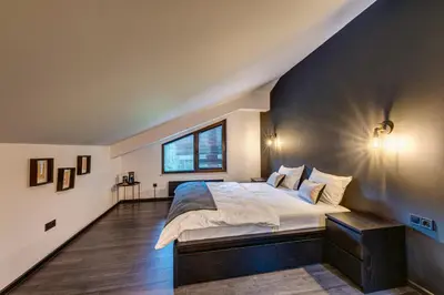 a bedroom with a large bed and a window at Black Box Studio in Smolyan