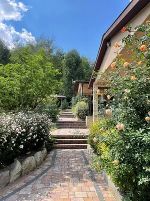 a brick path leading to a house with flowers at Комплекс Омайник in Kalofer