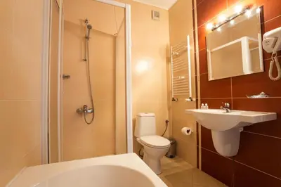 a bathroom with a toilet and a sink and a shower at Family Hotel Teteven in Teteven