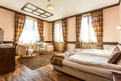 a hotel room with a bed and a table and chairs at Family Hotel Teteven in Teteven