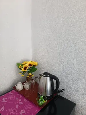a tea kettle and a vase of flowers on a table at The hiils 4 Plovdiv in Plovdiv