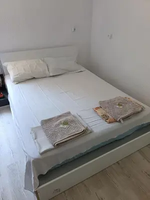 a bed with white sheets and towels on it at The hiils 4 Plovdiv in Plovdiv
