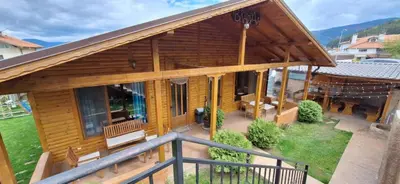 a log cabin with a porch and a balcony at Вила ВлаиДа in Sapareva Banya