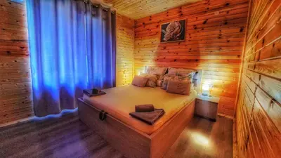 a bedroom with a bed in a wooden cabin at Вила ВлаиДа in Sapareva Banya