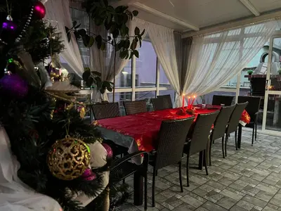a dining room with a table and a christmas tree at Къща за гости ТАТЯНА / GUEST HOUSE TATIANA in Petrich