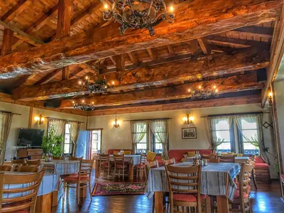 a dining room with tables and chairs and a chandelier at Hotel Leshten in Leshten
