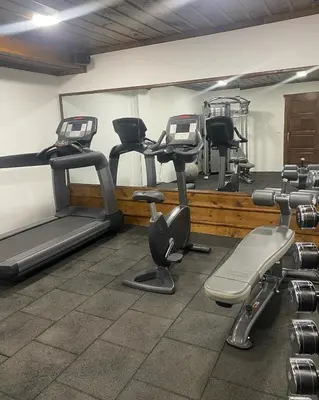 a gym with several exercise equipment in a room at Hotel Leshten in Leshten