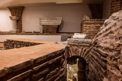 ancient ruins of a building with a sign on the wall at Villa Flavia Heritage Boutique Hotel in Plovdiv