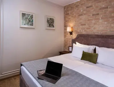 a hotel room with a bed with a laptop on it at Villa Flavia Heritage Boutique Hotel in Plovdiv