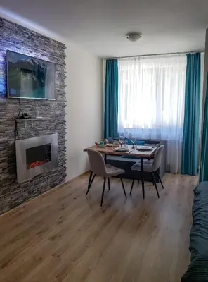 a dining room with a table and a fireplace at KLEPALSKI - Mountain Studio in Borovets