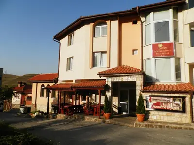 a building with a restaurant in front of it at Family Hotel Daisy in Borino