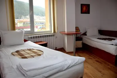 a small room with two beds and a window at Family Hotel Daisy in Borino