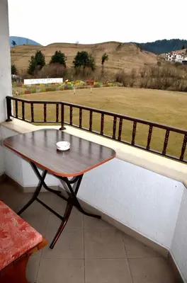 a table on a balcony with a view of a field at Family Hotel Daisy in Borino