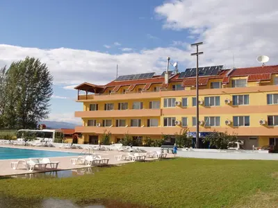 a large yellow building with chairs and a swimming pool at Komitite Complex in Chuchuligovo