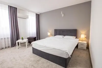 a bedroom with a large bed and two windows at Komitite Complex in Chuchuligovo