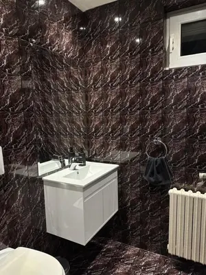a bathroom with a sink and a black tiled wall at Villa Alexa in Borovets