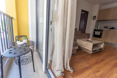 a view of a living room with a table and a window at Karastoyanovi's apartment- Studentski grad in Sofia