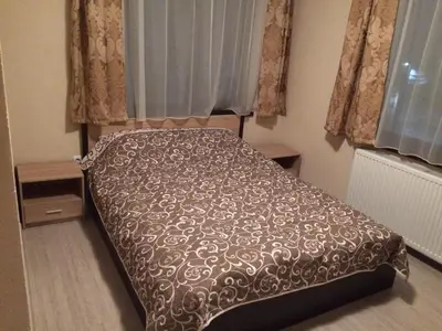 a bedroom with a bed with a brown comforter at Advel Guest House in Madzhare