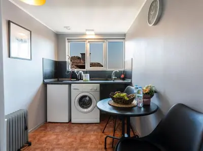 a small kitchen with a washing machine and a table at Lovely 1-bedroom apartment in the center of Sofia in Sofia