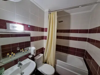 a bathroom with a toilet and a tub and a sink at Гранд Манастира Лукс in Pamporovo