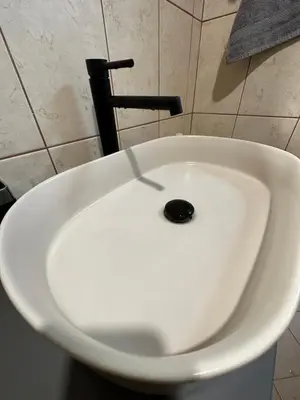 a white sink with a black drain in a bathroom at Apartaments Filipopolis in Plovdiv