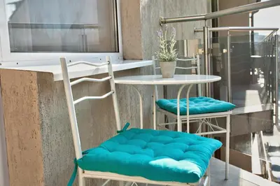 two chairs with blue cushions sitting next to a table at Aurora Oasis - AC & Lift in Vibrant Downtown Sofia by Flat Mаnager in Sofia