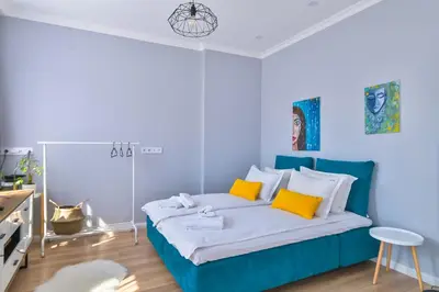 a blue and white bedroom with a bed with yellow pillows at - The Blue Apartment - 1BD with Artistic Interior Design by Flat Mаnager in Sofia
