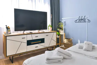 a living room with two beds and a television on a dresser at - The Blue Apartment - 1BD with Artistic Interior Design by Flat Mаnager in Sofia