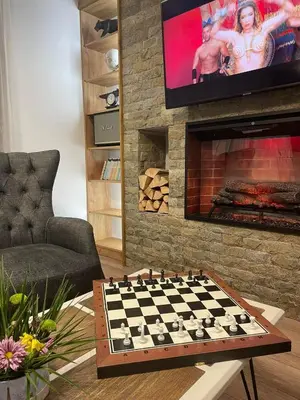 a living room with a chessboard in front of a fireplace at 4U LUXURY VILLA in Dospat