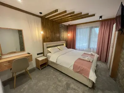 a bedroom with a bed and a desk and a mirror at 4U LUXURY VILLA in Dospat