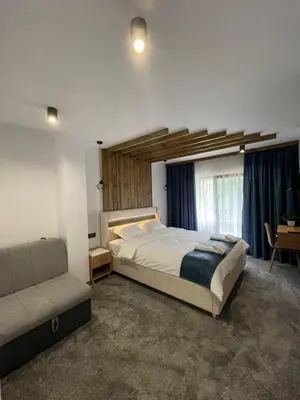 a bedroom with a large bed and a couch at 4U LUXURY VILLA in Dospat