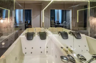 a bathroom with a large mirror and a sink at Luxury Vitosha Apartment in Sofia