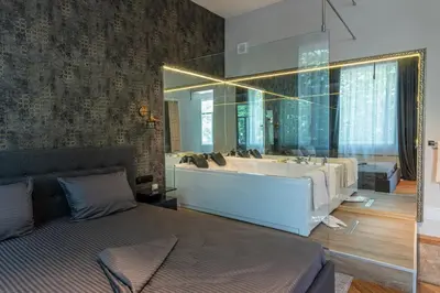 a bathroom with a bed and a sink and a mirror at Luxury Vitosha Apartment in Sofia
