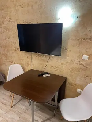 a table with chairs and a television on a wall at Colonel apartment 936 in Sofia