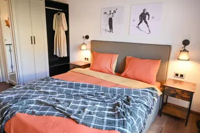 a bedroom with a bed with orange and blue sheets at Marand Villas in Bansko