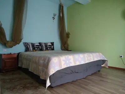 a bedroom with a bed with a pink bedspread at Dionis Hotel in Petrich